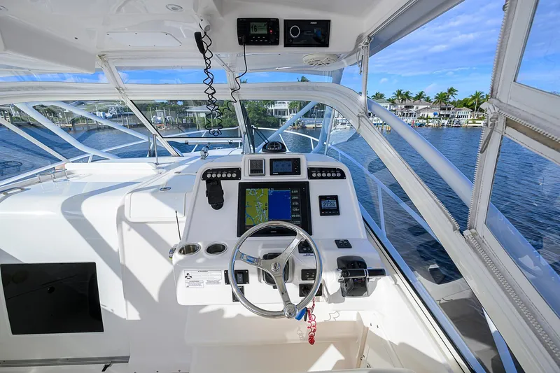  Yacht Photos Pics 2016 Edgewater 335 Express boat cockpit with navigation system and steering wheel, dockside view.