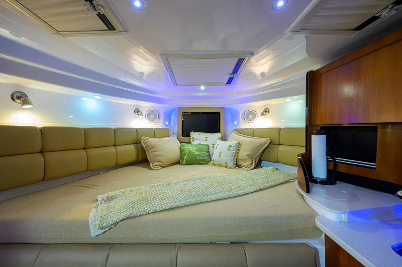  Yacht Photos Pics Luxurious interior cabin of 2016 Edgewater 335 Express boat with cozy bedding and ambient lighting.