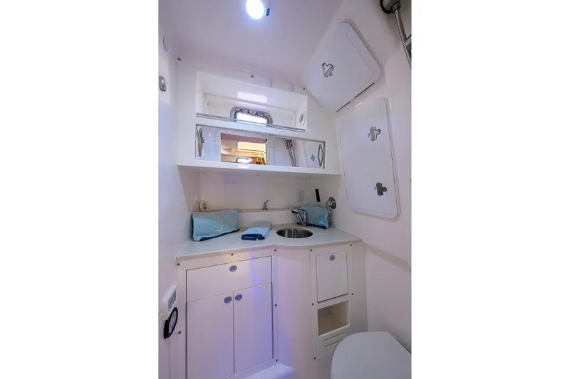  Yacht Photos Pics 2016 Edgewater 335 Express boat interior with compact bathroom and storage cabinets.