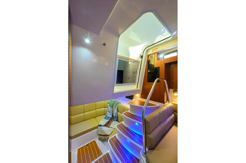  Yacht Photos Pics Interior of 2016 Edgewater 335 Express boat with modern seating and illuminated stairs.