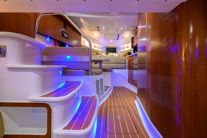  Yacht Photos Pics Luxurious interior of 2016 Edgewater 335 Express boat with ambient lighting and wooden finishes.
