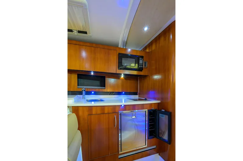  Yacht Photos Pics 2016 Edgewater 335 Express boat interior kitchen with microwave, sink, and mini fridge.