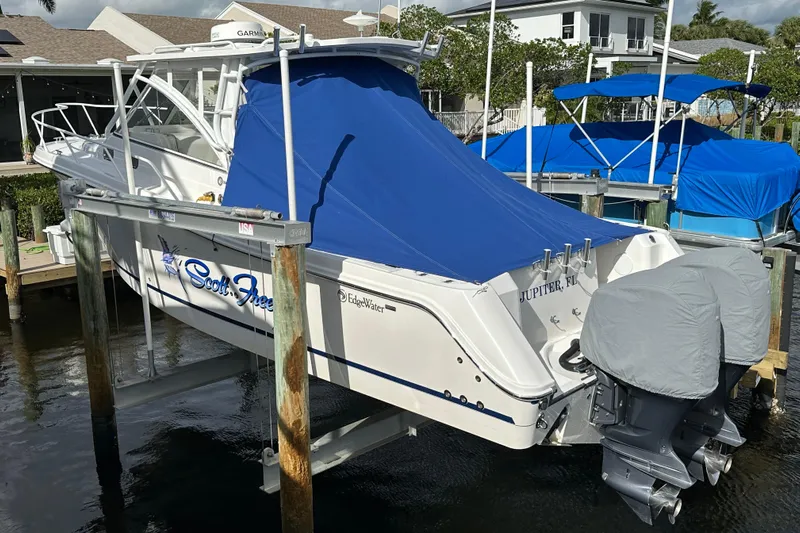  Yacht Photos Pics 2016 Edgewater 335 Express boat docked with blue cover, dual engines, and white hull.