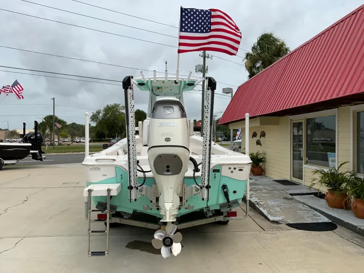  Yacht Photos Pics 2021 Blue Wave 2800 Makaira boat with American flag, docked near a red-roofed building.