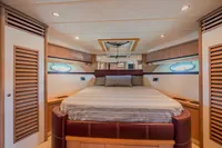 Luxurious bedroom interior of 2005 Astondoa 53 Open yacht with elegant wood finishes.