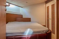 Luxurious cabin interior of 2005 Astondoa 53 Open yacht with cozy bed and wooden accents.