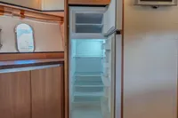 Interior of 2005 Astondoa 53 Open yacht with open fridge and wall-mounted TV.