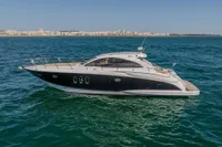 2005 Astondoa 53 Open yacht cruising on blue ocean near coastline.