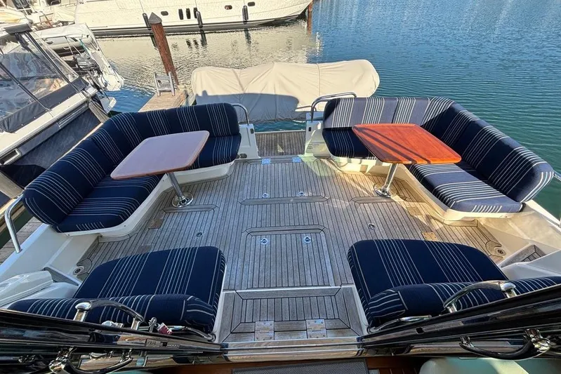 Salish Sky Yacht Photos Pics Luxurious 2015 Sabre 54 Salon Express yacht deck with striped seating and wooden tables.