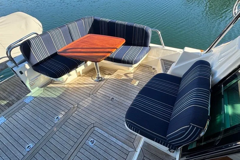 Salish Sky Yacht Photos Pics 2015 Sabre 54 Salon Express yacht deck with striped seating and wooden table.
