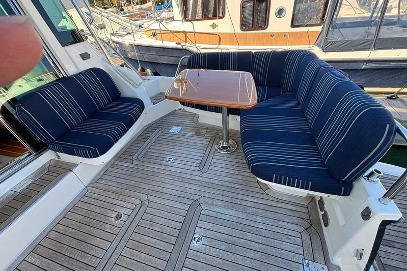 Salish Sky Yacht Photos Pics 2015 Sabre 54 Salon Express yacht with striped seating and wooden table on deck.