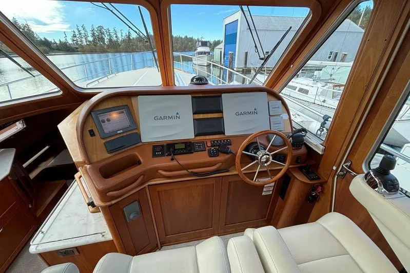 Salish Sky Yacht Photos Pics 2015 Sabre 54 Salon Express helm with Garmin navigation, wooden steering wheel, and marina view.