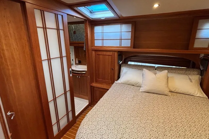 Salish Sky Yacht Photos Pics Luxurious 2015 Sabre 54 Salon Express bedroom with elegant wood paneling and cozy bedding.