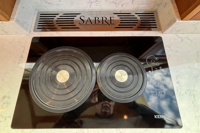 Salish Sky Yacht Photos Pics Stovetop on 2015 Sabre 54 Salon Express yacht, featuring Kenyon burners and Sabre branding.