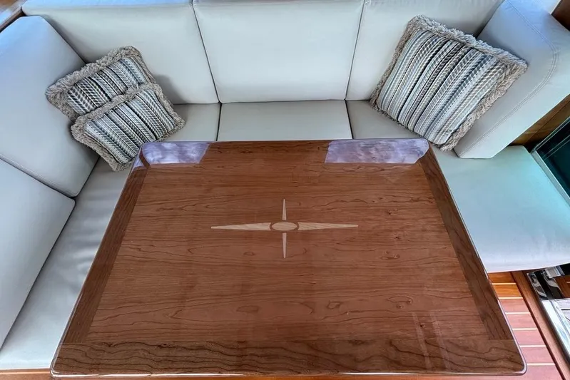 Salish Sky Yacht Photos Pics Luxurious interior of 2015 Sabre 54 Salon Express with elegant wooden table and plush cushions.