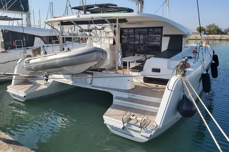 Mojito Yacht Photos Pics 2020 Lagoon 42 catamaran docked with inflatable dinghy, showcasing modern design and spacious deck.
