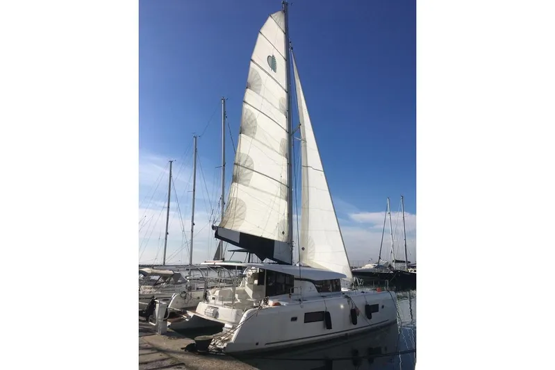 Mojito Yacht Photos Pics 2020 Lagoon 42 catamaran docked at marina under clear blue sky.