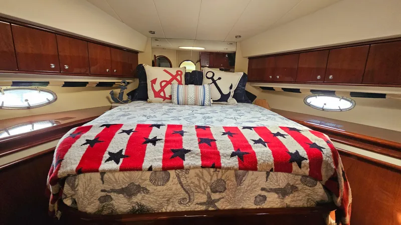 Dream Team Xiii Yacht Photos Pics Luxurious 2005 Neptunus 56 Flybridge yacht bedroom with nautical-themed decor.