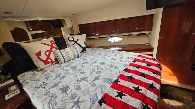 Dream Team Xiii Yacht Photos Pics Luxurious bedroom in 2005 Neptunus 56 Flybridge yacht with nautical-themed decor.