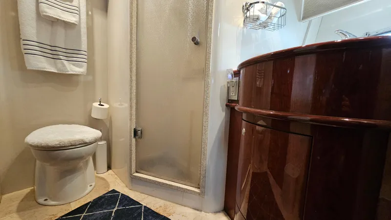 Dream Team Xiii Yacht Photos Pics Luxurious bathroom in 2005 Neptunus 56 Flybridge yacht with shower and wooden cabinetry.