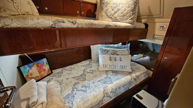 Dream Team Xiii Yacht Photos Pics Cozy cabin interior of 2005 Neptunus 56 Flybridge yacht with nautical-themed bedding.