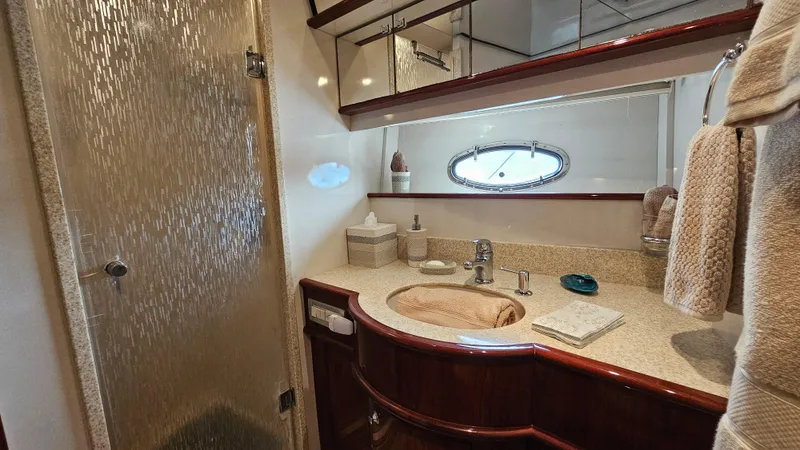 Dream Team Xiii Yacht Photos Pics Luxurious bathroom in 2005 Neptunus 56 Flybridge yacht with elegant fixtures and porthole window.