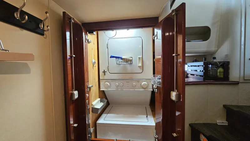 Dream Team Xiii Yacht Photos Pics Laundry area inside 2005 Neptunus 56 Flybridge yacht with stacked washer and dryer.