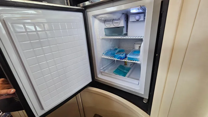 Dream Team Xiii Yacht Photos Pics Open refrigerator on 2005 Neptunus 56 Flybridge yacht, showing organized interior shelves.