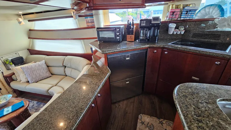 Dream Team Xiii Yacht Photos Pics Luxurious 2005 Neptunus 56 Flybridge yacht interior with modern kitchen and cozy seating area.