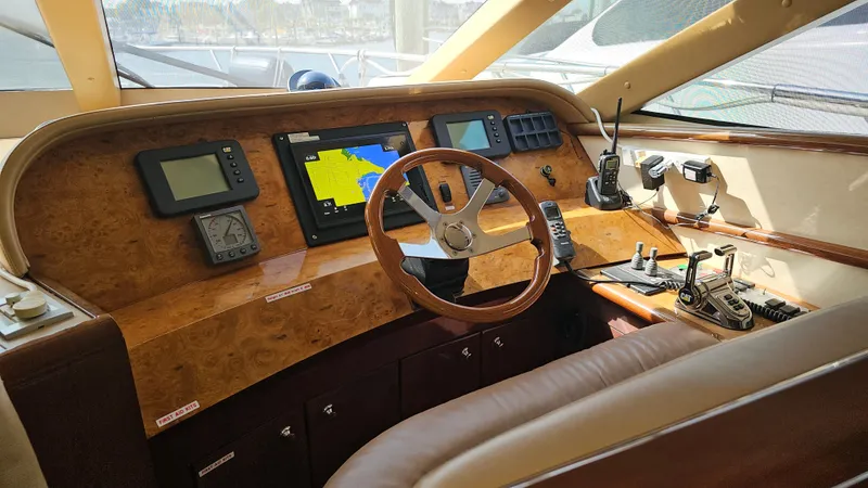 Dream Team Xiii Yacht Photos Pics Helm of 2005 Neptunus 56 Flybridge yacht with navigation equipment and wooden steering wheel.