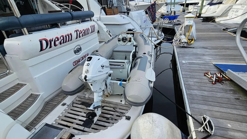 Dream Team Xiii Yacht Photos Pics 2005 Neptunus 56 Flybridge yacht with inflatable boat at marina dock.