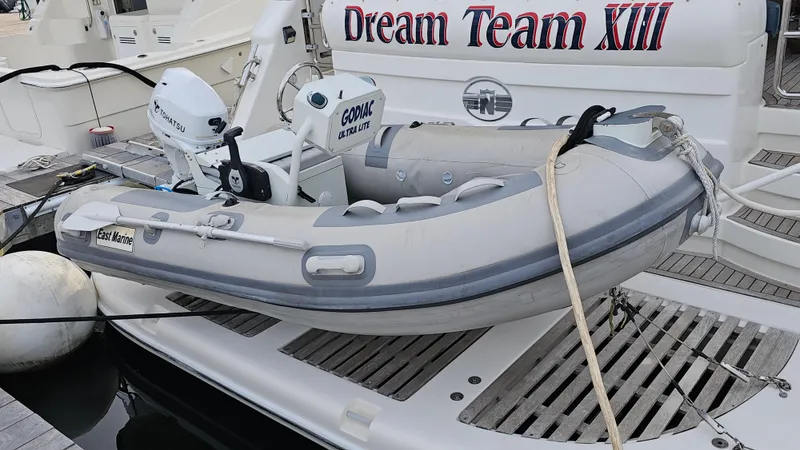 Dream Team Xiii Yacht Photos Pics Inflatable dinghy on Neptunus 56 Flybridge yacht, 2005 model, docked with "Dream Team XIII" signage.