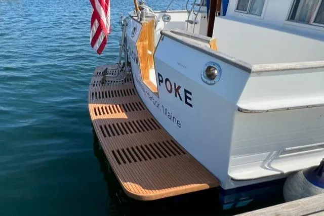 Slow Poke Yacht Photos Pics 1987 Grand Banks Classic Trawler docked, featuring wooden swim platform and American flag.