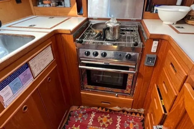 Slow Poke Yacht Photos Pics 1987 Grand Banks Classic Trawler kitchen with stove, oven, and wooden cabinetry.