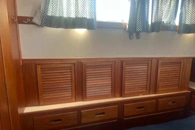 Slow Poke Yacht Photos Pics 1987 Grand Banks Classic Trawler interior with wooden cabinets and drawers under a window.