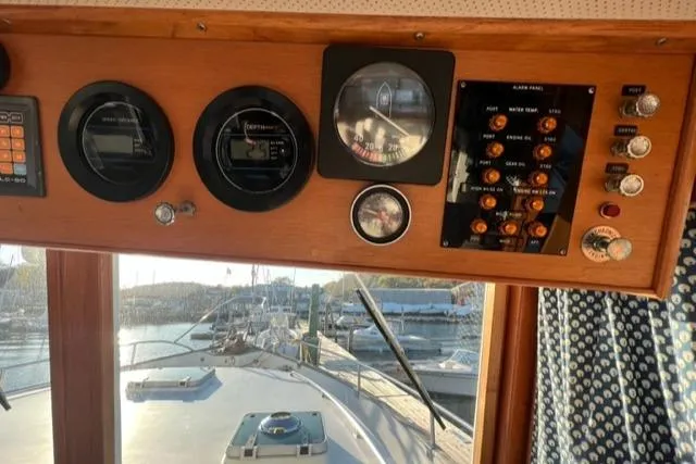 Slow Poke Yacht Photos Pics 1987 Grand Banks Classic Trawler dashboard with gauges and controls, overlooking marina.