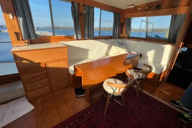 Slow Poke Yacht Photos Pics 1987 Grand Banks Classic Trawler interior with wood finish, dining area, and scenic window views.