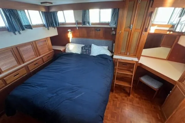 Slow Poke Yacht Photos Pics 1987 Grand Banks Classic Trawler bedroom with wood paneling and cozy bedding.