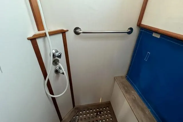 Slow Poke Yacht Photos Pics Shower area in 1987 Grand Banks Classic Trawler, featuring wooden accents and blue panel.