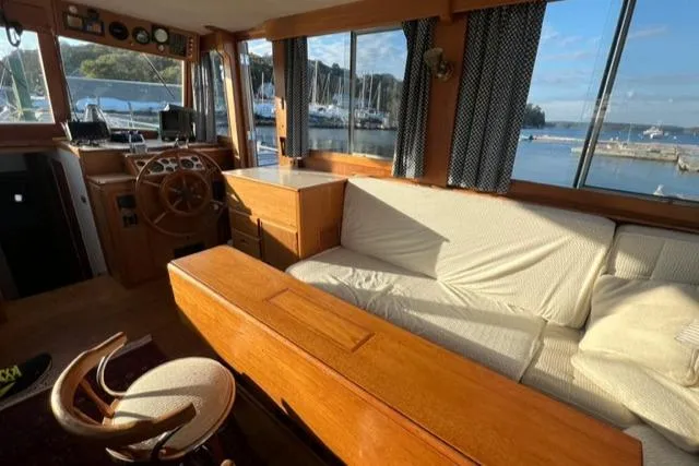 Slow Poke Yacht Photos Pics Interior of 1987 Grand Banks Classic Trawler, featuring wooden furnishings and marina view.