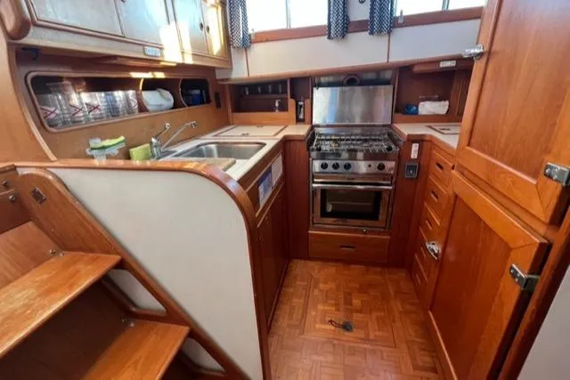 Slow Poke Yacht Photos Pics 1987 Grand Banks Classic Trawler kitchen with wooden cabinetry, stove, and sink.