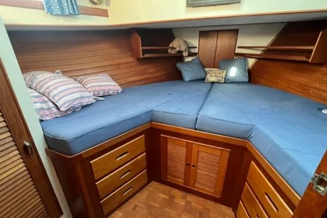 Slow Poke Yacht Photos Pics 1987 Grand Banks Classic Trawler cabin with blue cushions and wooden storage drawers.