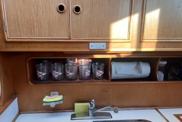 Slow Poke Yacht Photos Pics 1987 Grand Banks Classic Trawler kitchen with wooden cabinets, glasses, and a sink.