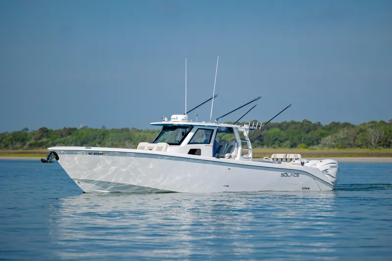  Yacht Photos Pics 2022 Solace 41 CS boat on calm water, featuring sleek design and fishing rods.