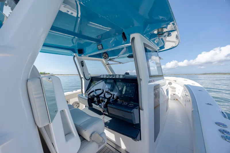  Yacht Photos Pics 2022 Solace 41 CS boat interior with modern helm and blue canopy on open water.