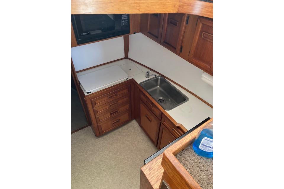 1979 Pacemaker 40 Sportfisher kitchen with wooden cabinets, sink, and countertop.