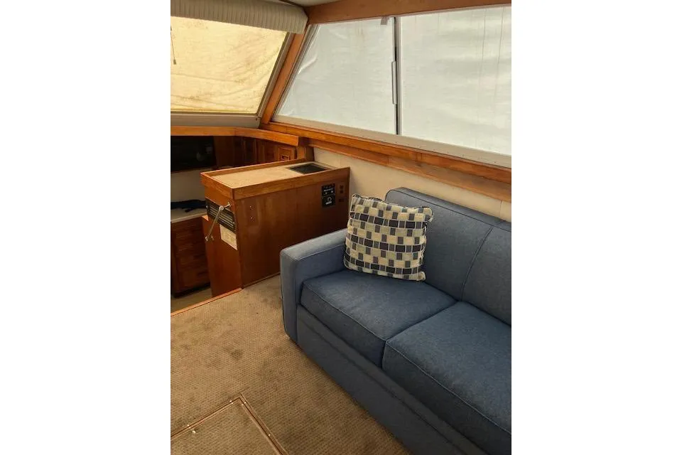 Interior of 1979 Pacemaker 40 Sportfisher with blue sofa and checkered pillow.