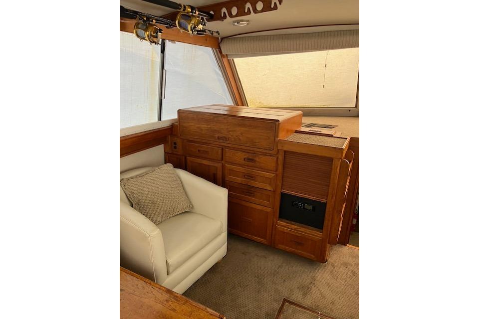 Interior of 1979 Pacemaker 40 Sportfisher with wooden cabinetry and white armchair.