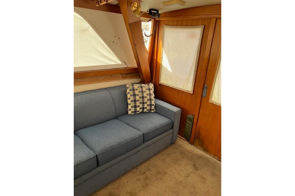 Interior of 1979 Pacemaker 40 Sportfisher with blue sofa and checkered pillow.