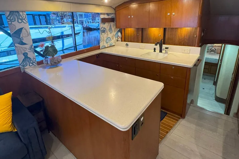 Happy Our's Yacht Photos Pics Interior of 1997 Ocean Yachts 48 Super Sport, featuring a spacious kitchen with wooden cabinetry.